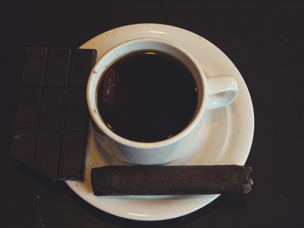 Café, chocolate y puro en mesa