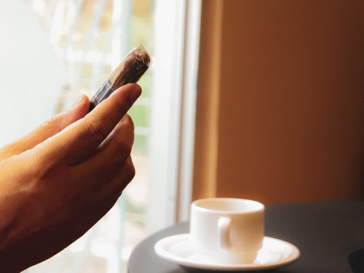 Puro y café junto a una ventana